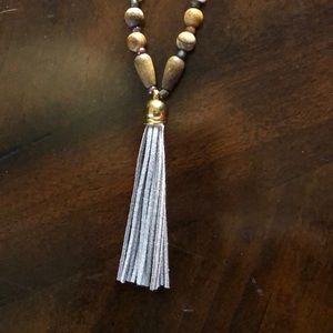 Hand-beaded wood necklace with leather tassel.